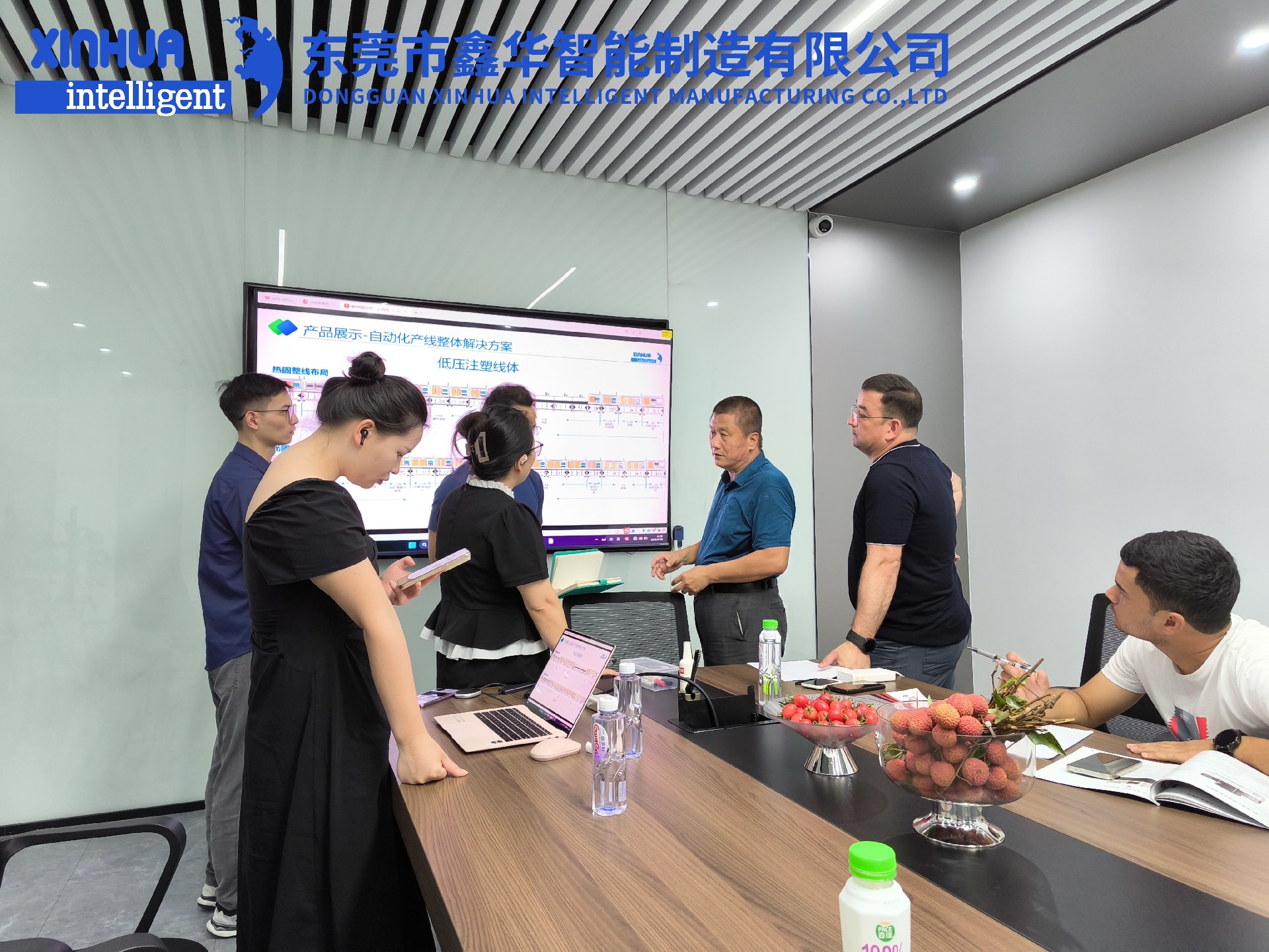 三位蒙古客戶在會議室聽取外貿(mào)業(yè)務(wù)員小劉的講解