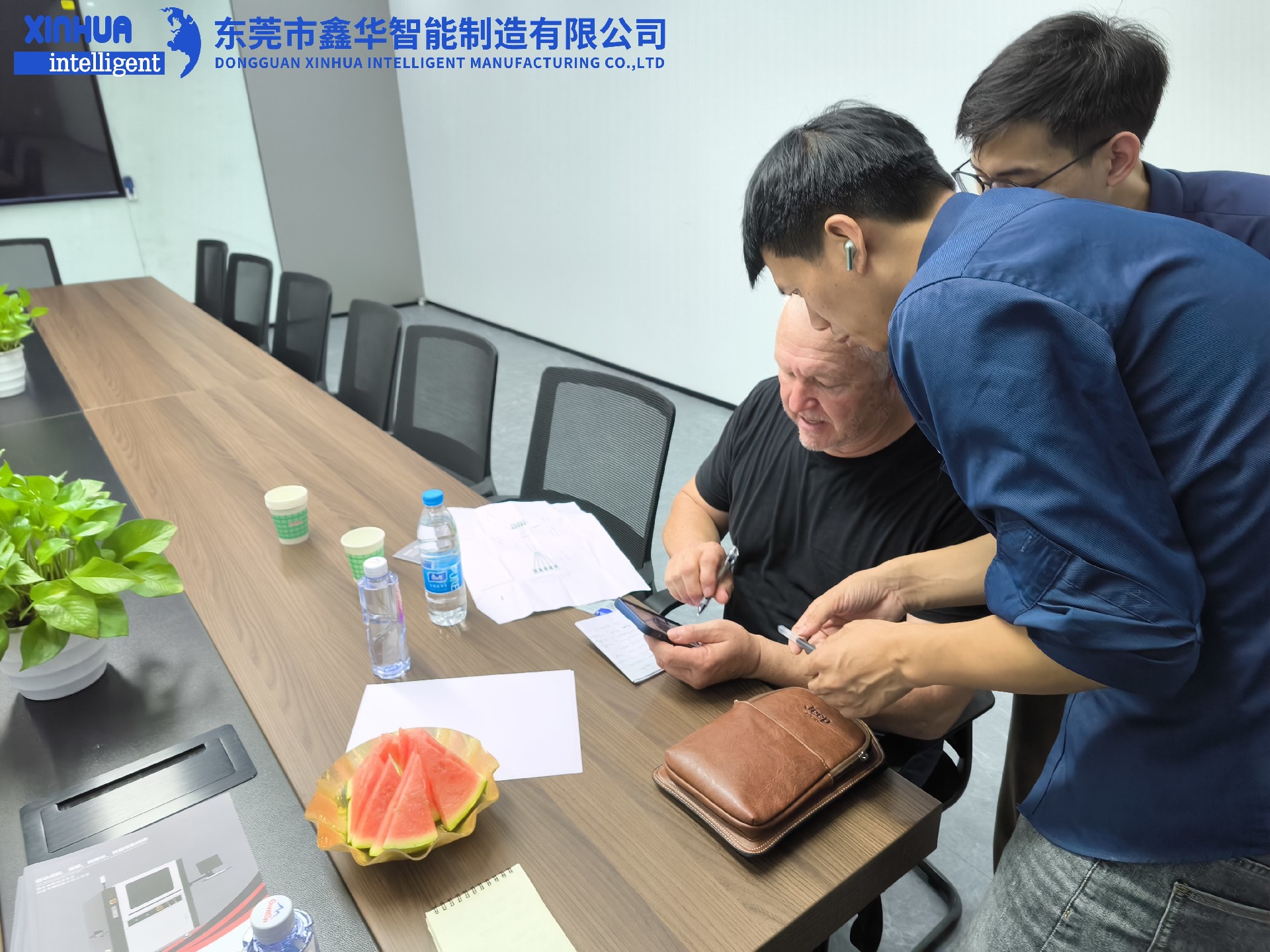 業(yè)務(wù)部2位男同事在給美國客戶耐心介紹自動鎖螺絲機(jī)性能